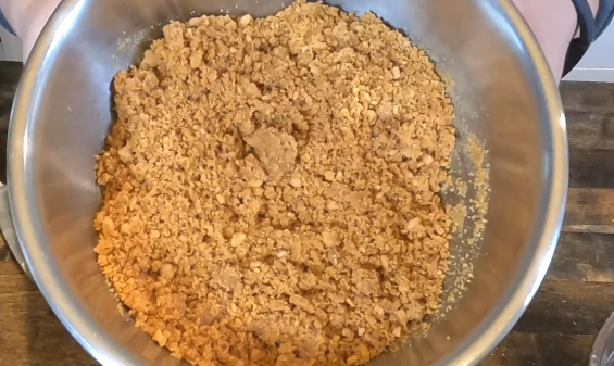 graham cracker crumbles mixed with brown sugar and butter in a stainless steel bowl
