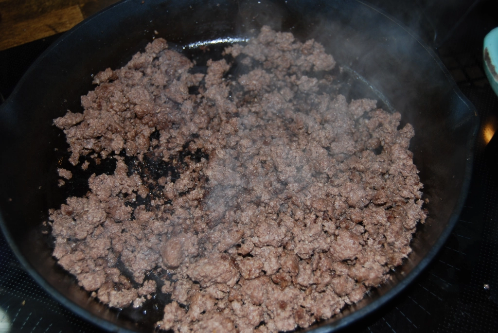 browned ground beef in a cast iron skillet