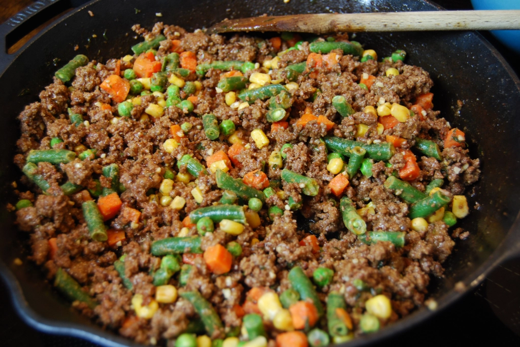 meat and vegetable mixture in a cast iron skillet