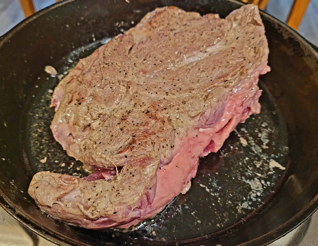 browned pot roast in cast iron skillet