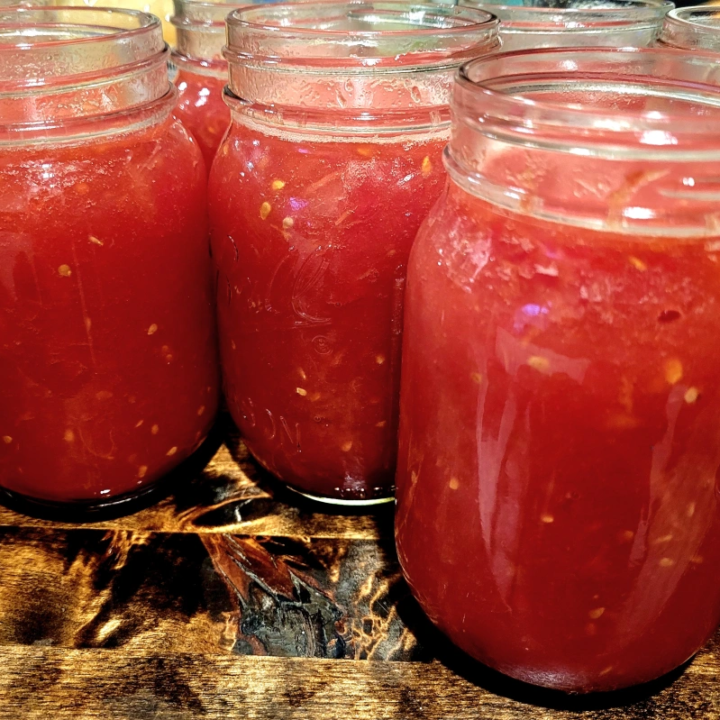 Jars of crushed tomatoes on butcher block counter