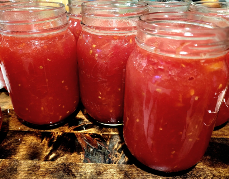 Jars of crushed tomatoes on butcher block counter