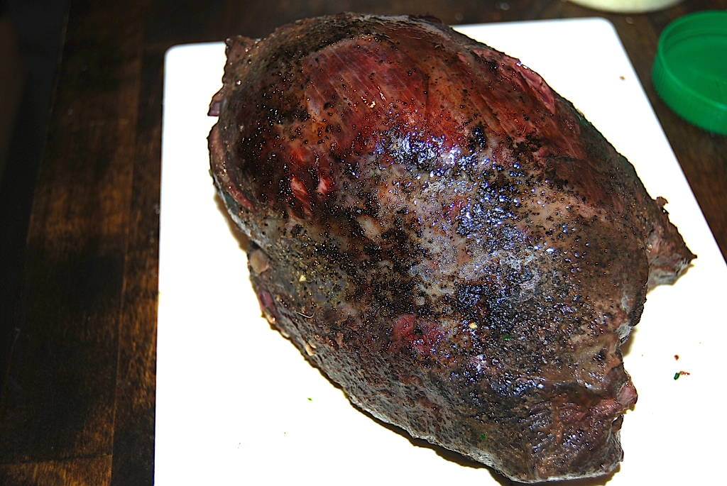 seared venison roast on a white cutting board