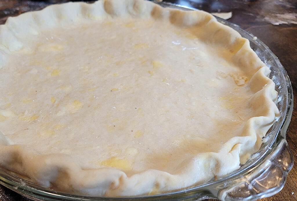 pot pie in glass pie dish with fluted edges