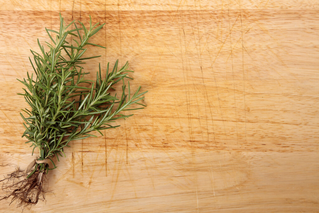 bunch of fresh rosemary on an old wooden chopping board