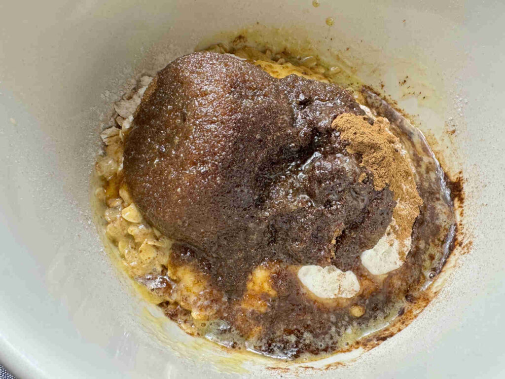 1/2 cup of brown sugar, 1 tsp cinnamon 1/2 cup of flour on top of oats with melted butter poured on top in a white bowl