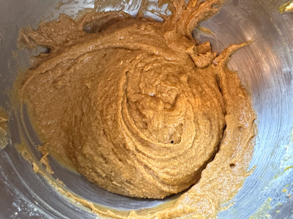 fully mixed pumpkin and apple cider bread batter in a stainless steel mixing bowl
