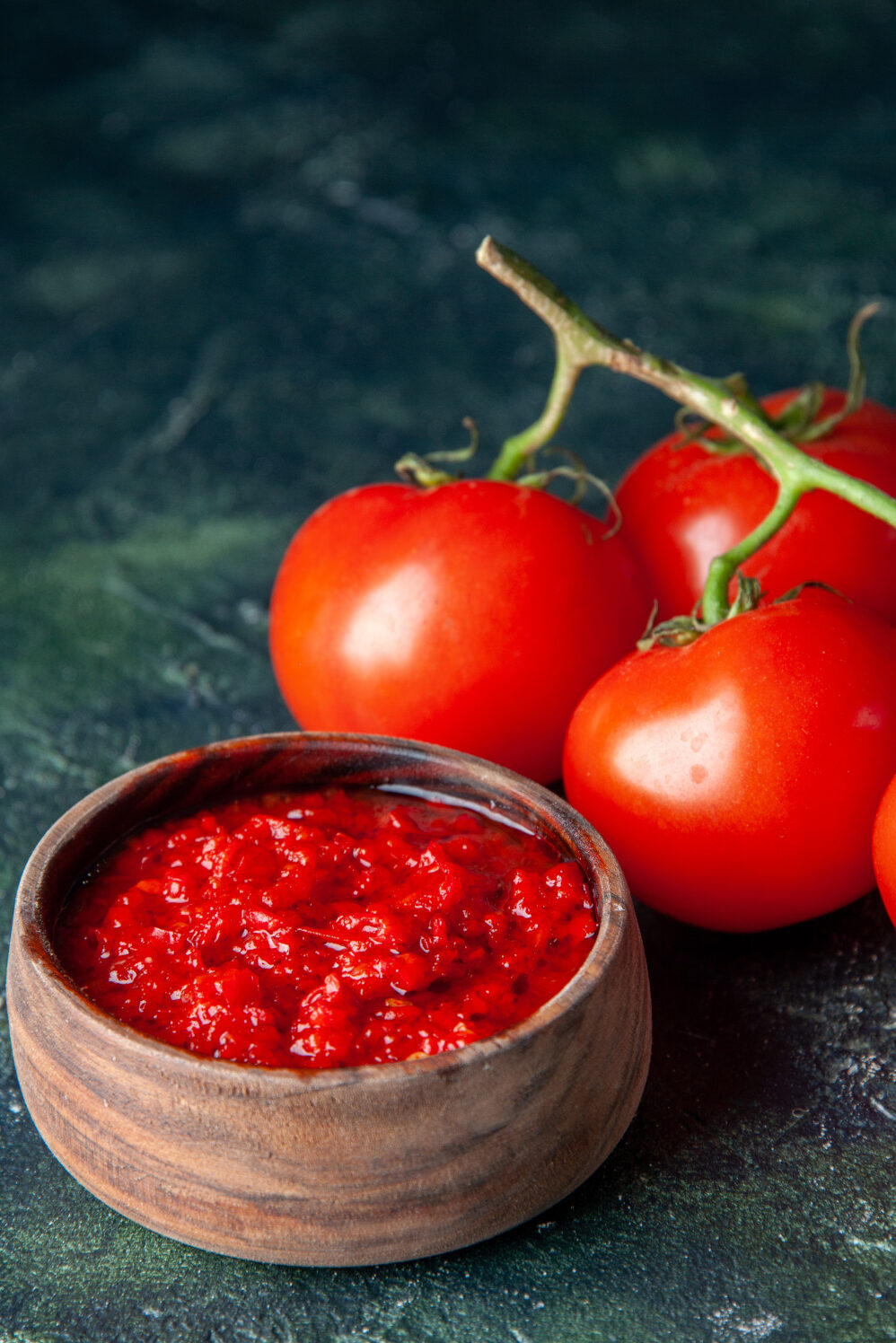 front-view-crushed tomatoes-with-fresh-red-tomatoes-dark-blue-surface