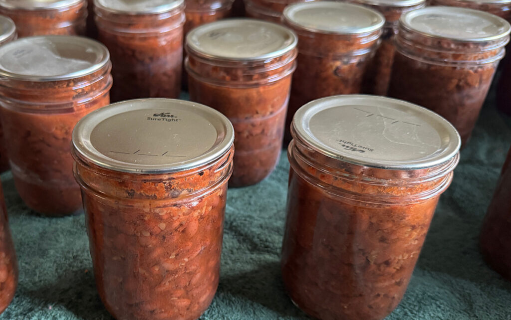 jars of seasoned black beans on a green towel lined table