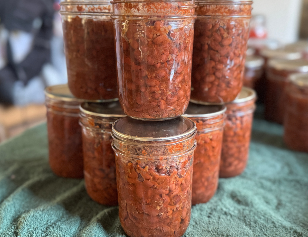 jars of seasoned black beans on a green towel lined table