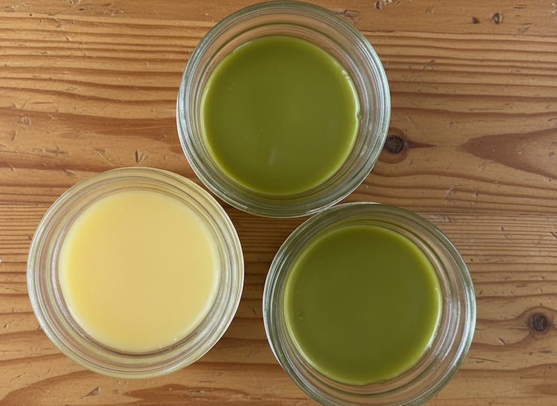 3 jars of salves on a light colored wooden table