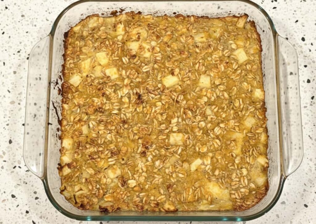 apple butternut squash baked oatmeal in an 8x8 glass baking dish on a light colored granite countertop
