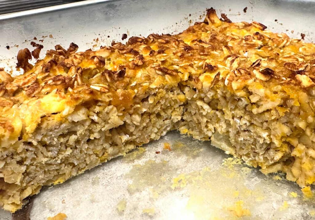 apple butternut squash baked oatmeal with a slice missing in an 8x8 glass baking dish