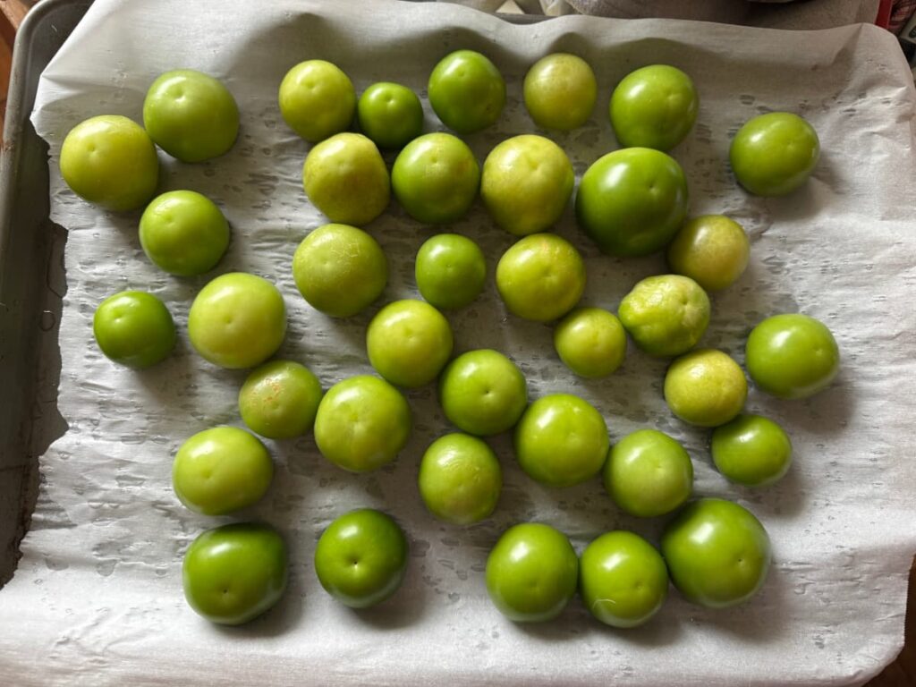 tomatillos on a parchment lined baking sheet