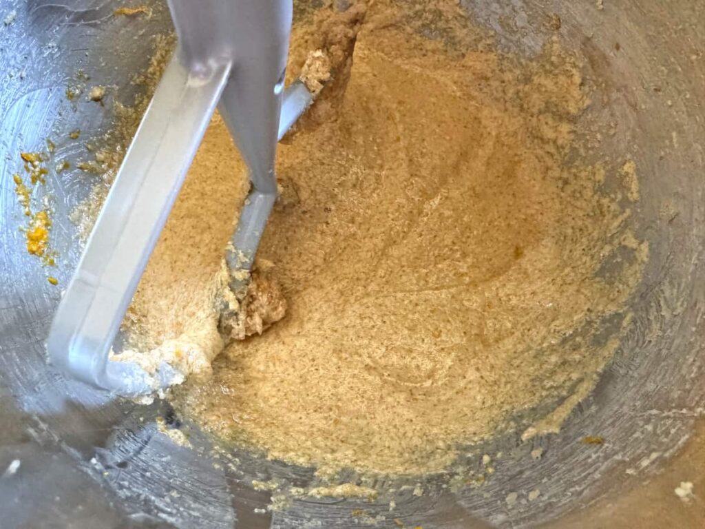 wet ingredients mixed together in a stainless steel stand mixer bowl with a paddle attachment