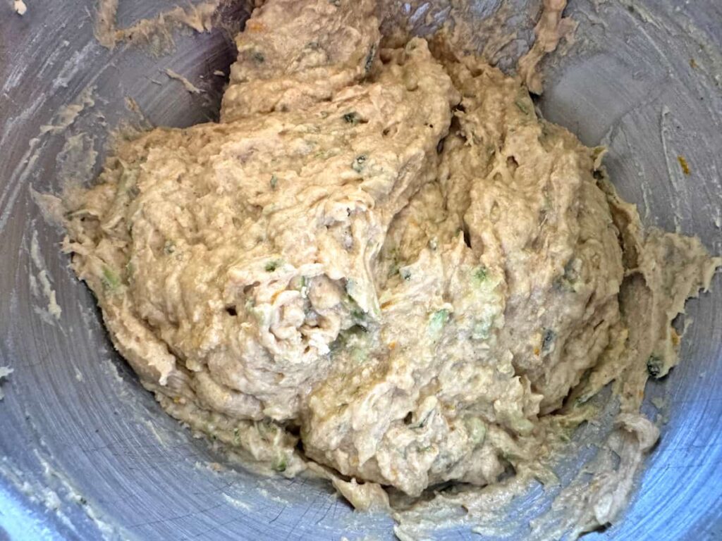 finished orange zucchini bread batter in a stainless steel bowl